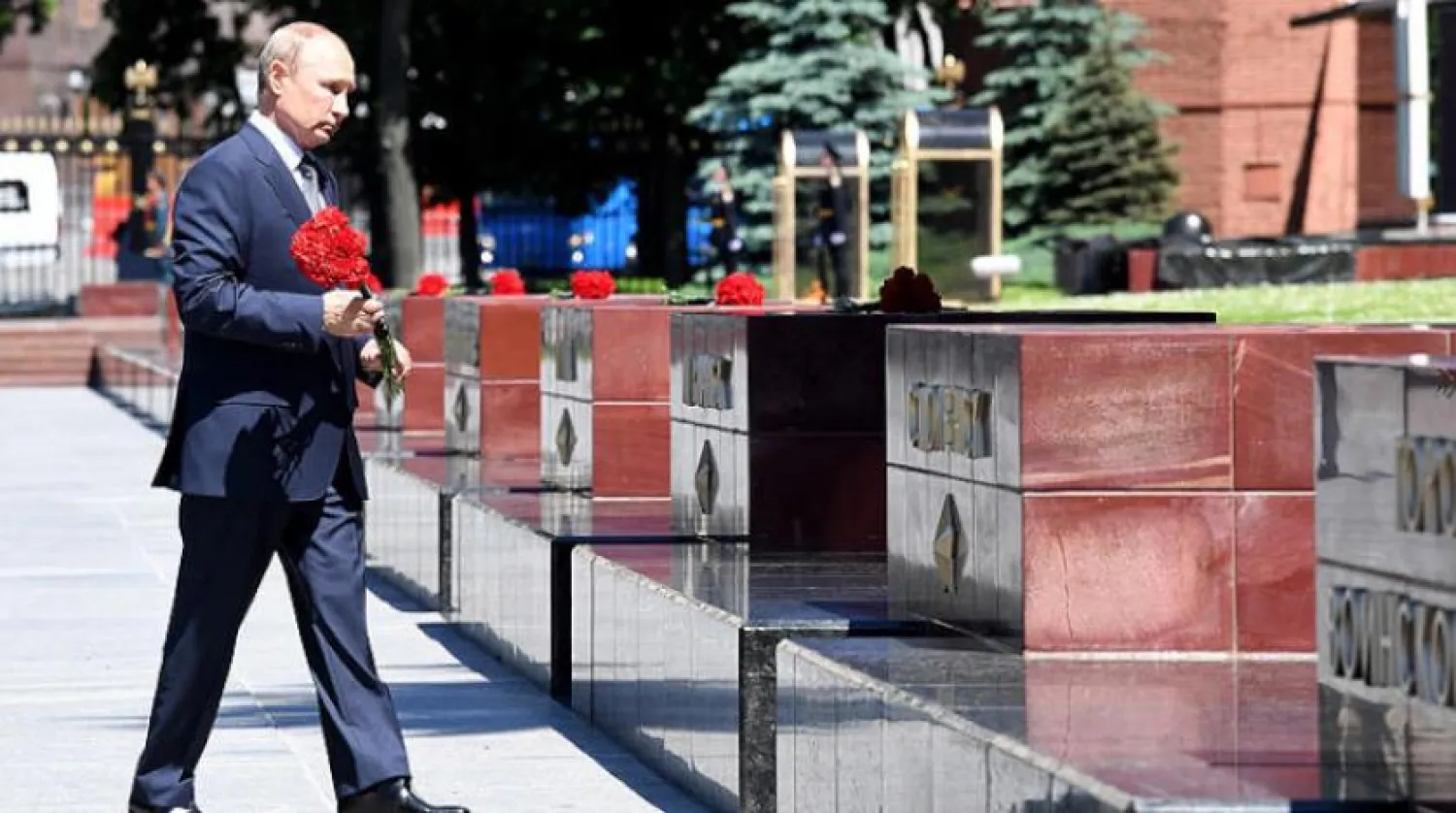 Putin asker anıtına çiçek bırakırken (EPA)