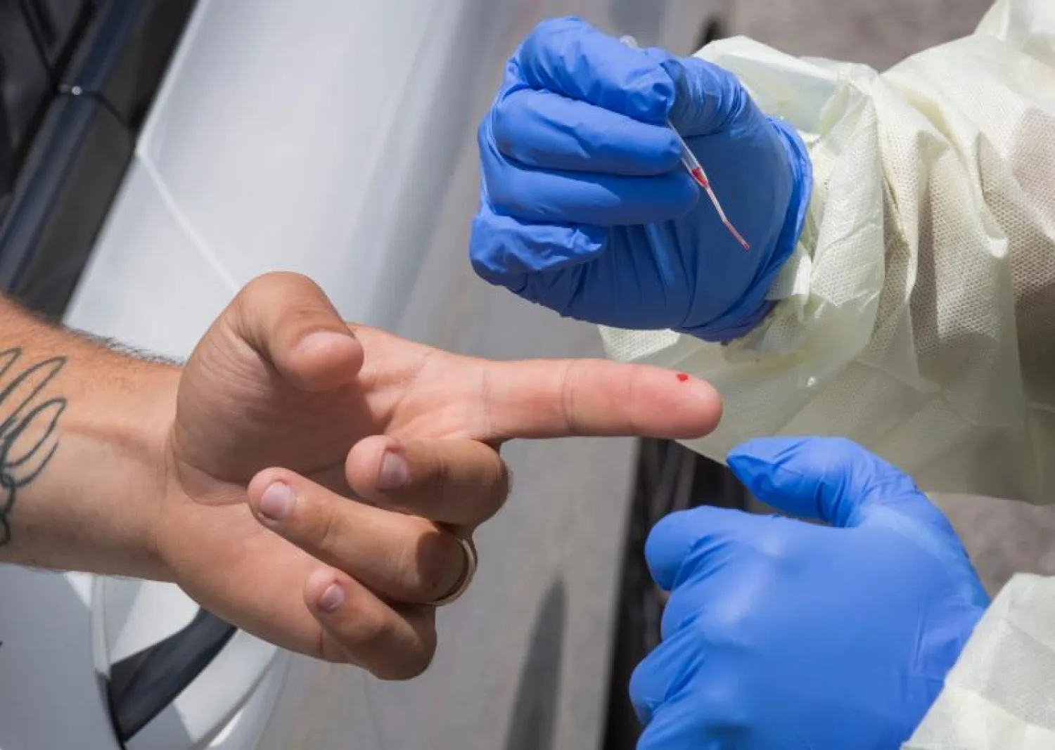 أحد العاملين في قطاع الرعاية الصحية يسحب عينة دم من مواطن أميركي (أ.ف.ب)