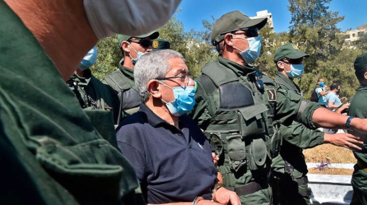 Former Algerian Prime Minister Ahmed Ouyahia wearing mask during the funeral of his brother, al-Aifa (AFP)
