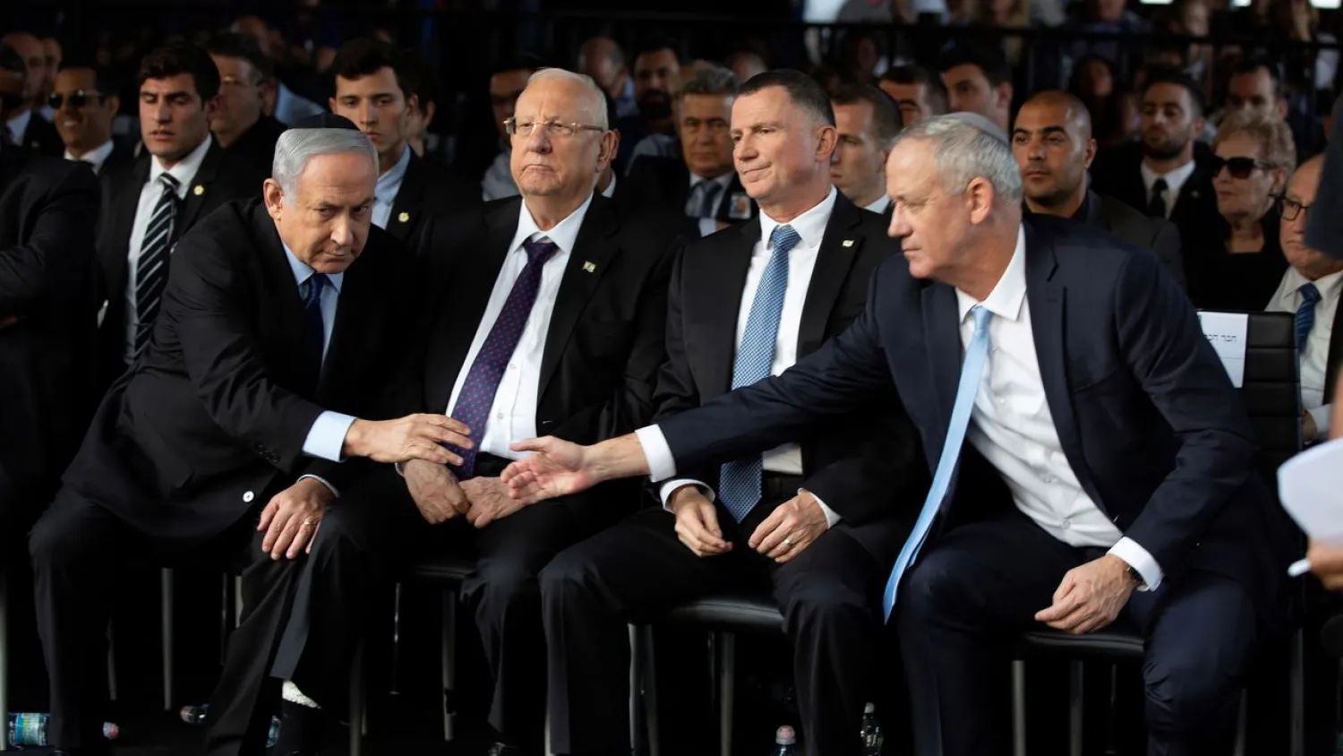 Head of Israel's Blue and White Party Benny Gantz (R) and Prime Minister Benjamin Netanyahu shake hands as they attend a memorial ceremony in Jerusalem, November 10, 2019. (Reuters)