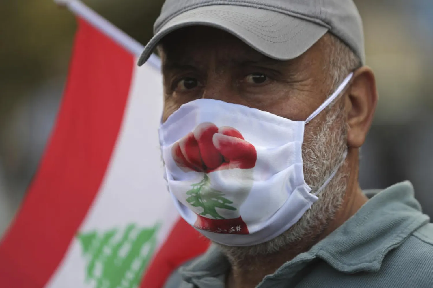 محتج لبناني يرتدي كمامة عليها العلم اللبناني خلال مظاهرات مناهضة للحكومة الأسبوع الماضي (أ.ب)