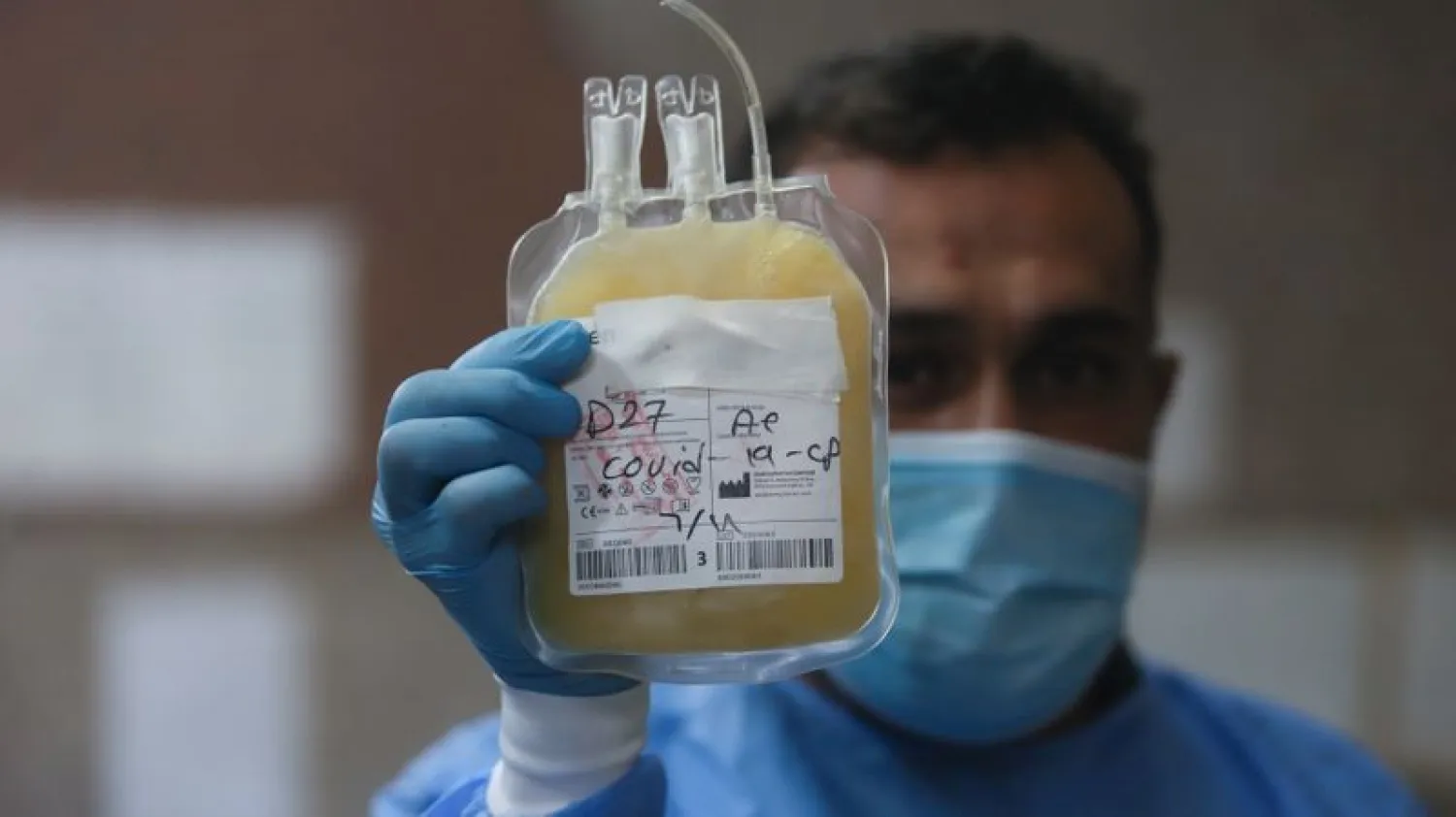A nurse shows blood plasma donated from a person who recovered from COVID-19 at a blood bank in Basra, Iraq, June 20, 2020. (Reuters)