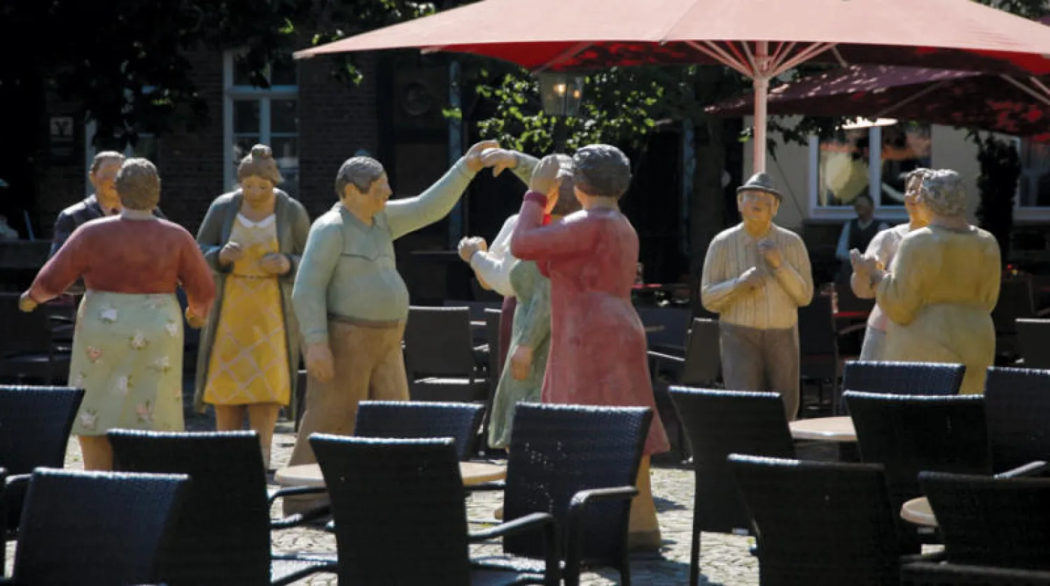 منحوتات لأشخاص بالقرب من مقاعد فارغة في وسط مدينة ألمانية (رويترز)