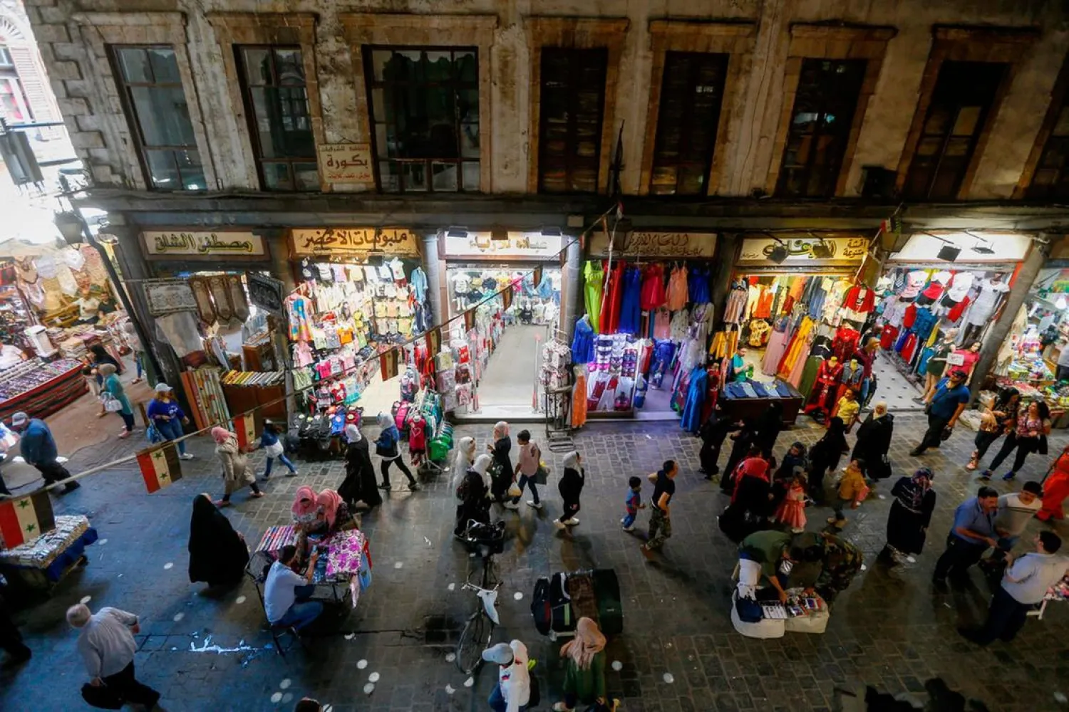 Syrian shoppers walk in the bazaar in old Damascus. (AFP)