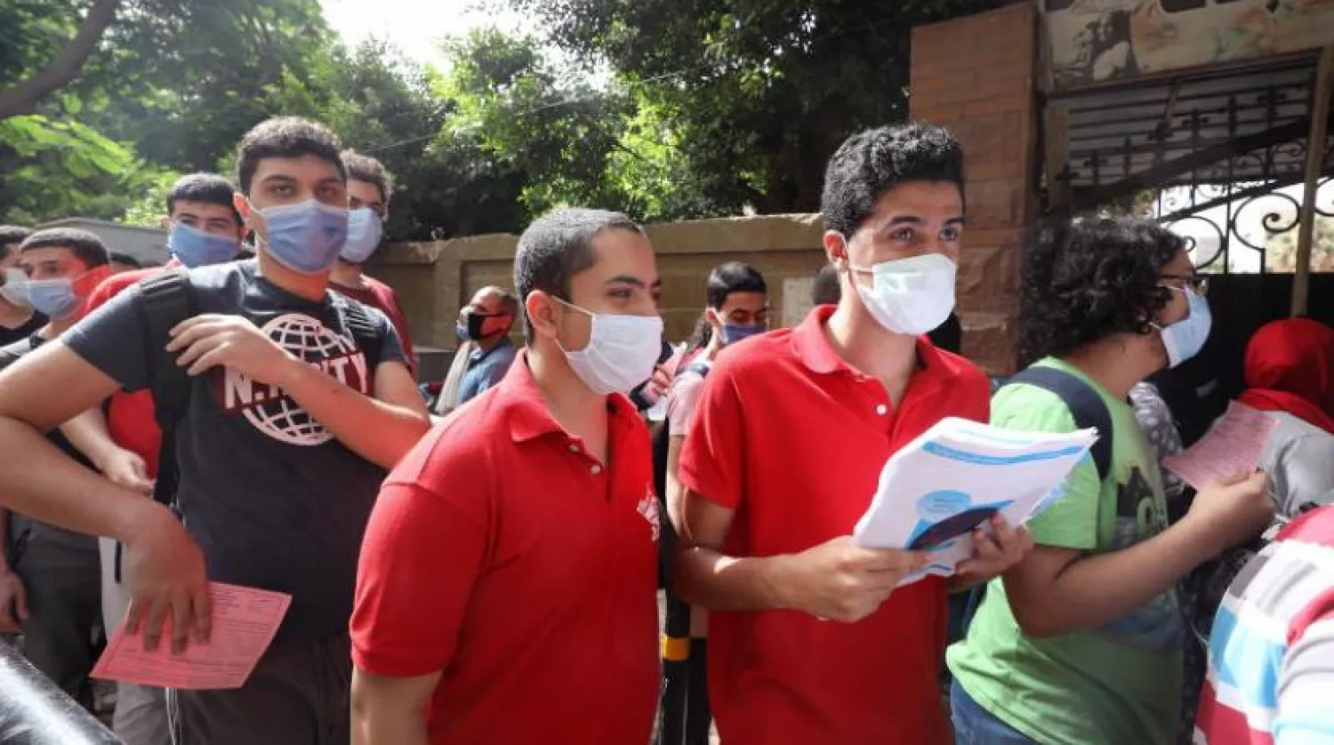 Kahire’de sınavdan önce okulun dışarısında bekleyen ve maske takan liseli öğrenciler (EPA)