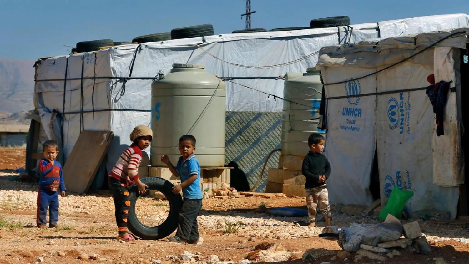 In this June 2017 file photo, Syrian refugee children play outside their family tents at a refugee camp in the eastern Lebanese city of Baalbek. AP
