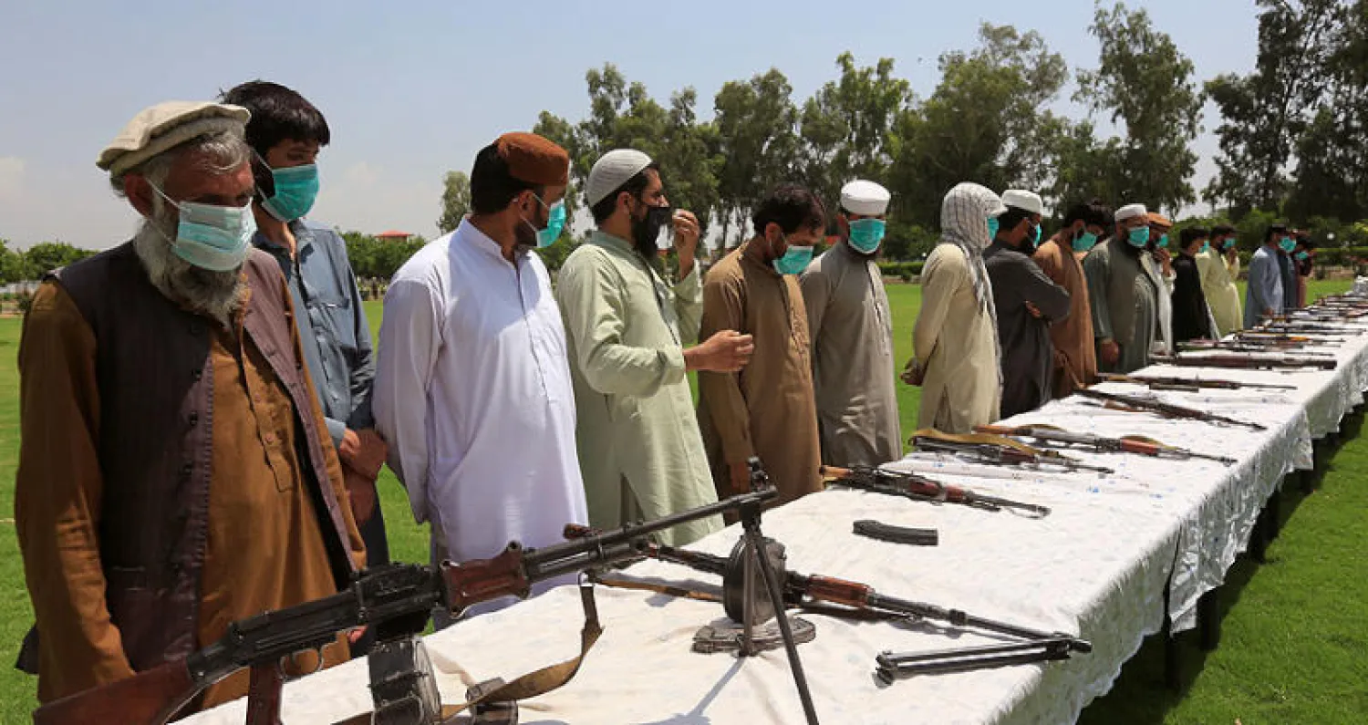 عناصر من «طالبان» يسلمون أسلحتهم في جلال آباد شرقي أفغانستان أول من أمس (رويترز)