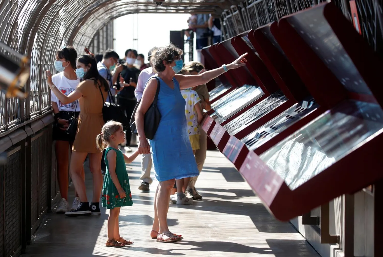 People wearing protective face masks visit the Eiffel Tower in Paris on its reopening day to the public following the coronavirus disease (COVID-19) outbreak in France, June 25, 2020. REUTERS/Charles Platiau