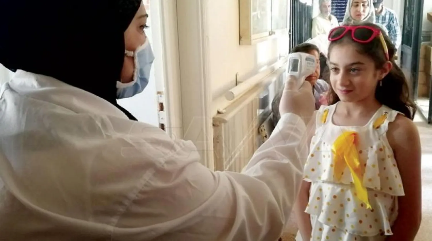 A nurse takes the temperature of a child. (Asharq Al-Awsat)