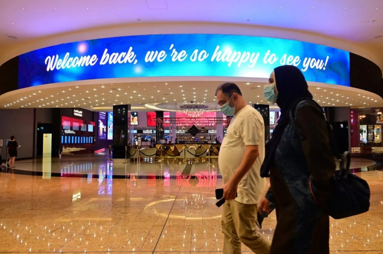 People wearing protective masks walk at the Dubai Mall on May 27. (AFP)