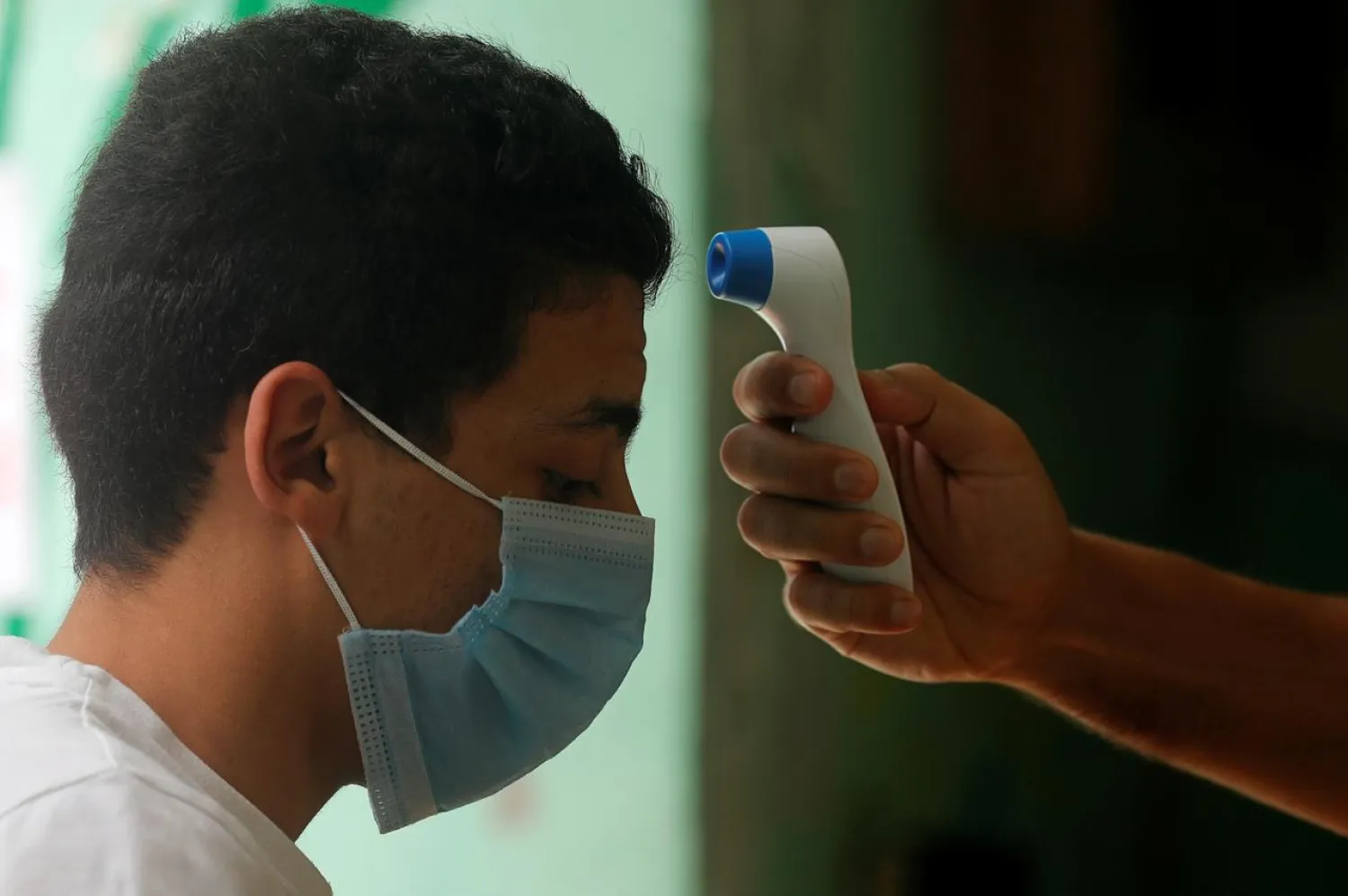 FILE PHOTO: A high school student has his temperature checked before the final exams, amid concerns over the coronavirus disease (COVID-19) outbreak, in Cairo, Egypt June 21, 2020. REUTERS/Amr Abdallah Dalsh