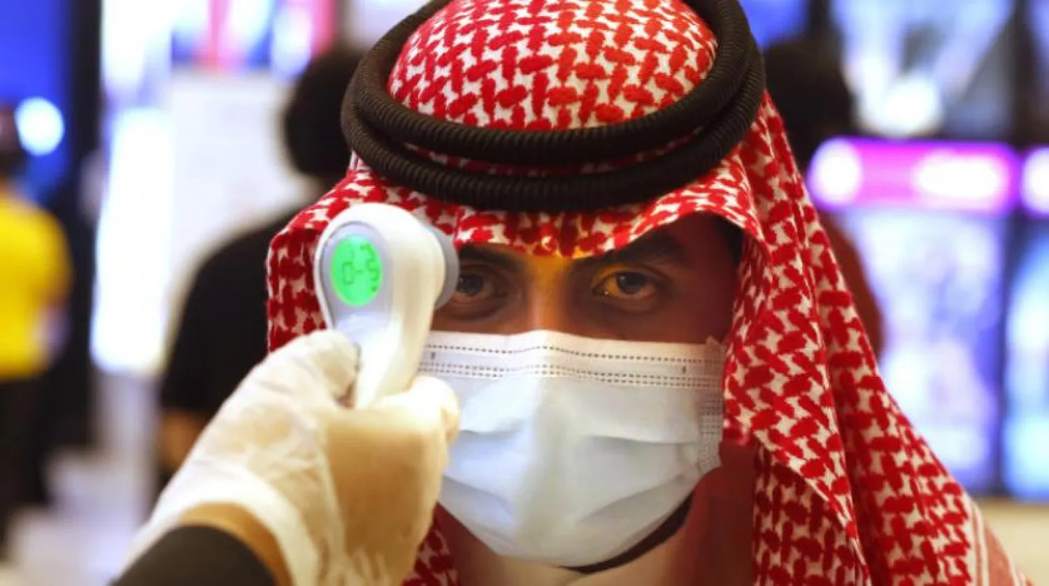 A Saudi man has his temperature taken as he wears a face mask to help curb the spread of the coronavirus in Jeddah, Saudi Arabia, Friday, June 26, 2020. (AP Photo/Amr Nabil)