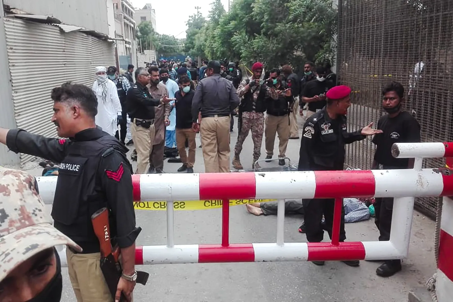 Policemen secure an area around a body outside the Pakistan Stock Exchange building after a group of gunmen attacked the building in Karachi on June 29, 2020. (Photo by Asif HASSAN / AFP)