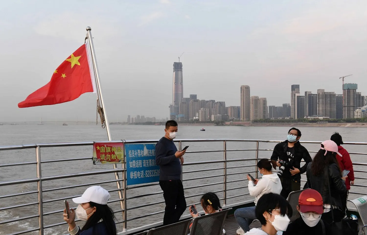 Passengers wearing face masks ride a ferry on Yangtze River after travel restrictions to leave Wuhan, China's epicenter of the coronavirus outbreak, were lifted, April 8, 2020. (Reuters)