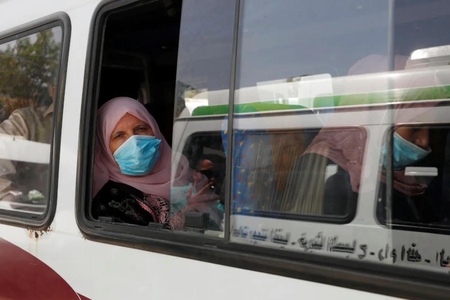 سيدة فلسطينية تضع كمامة في حافلة برام الله (رويترز)
