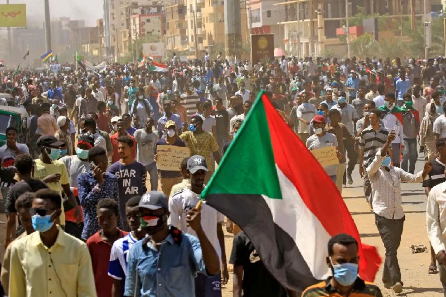 متظاهرون سودانيون يرتدون أقنعة واقية في الخرطوم (أ.ف.ب)