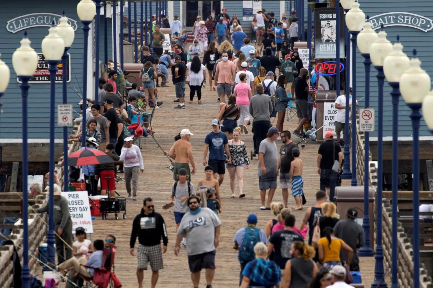 Few people wear masks as they walk on the beach pier during the global outbreak of the coronavirus in Oceanside, California, US, June 22, 2020. (Reuters)