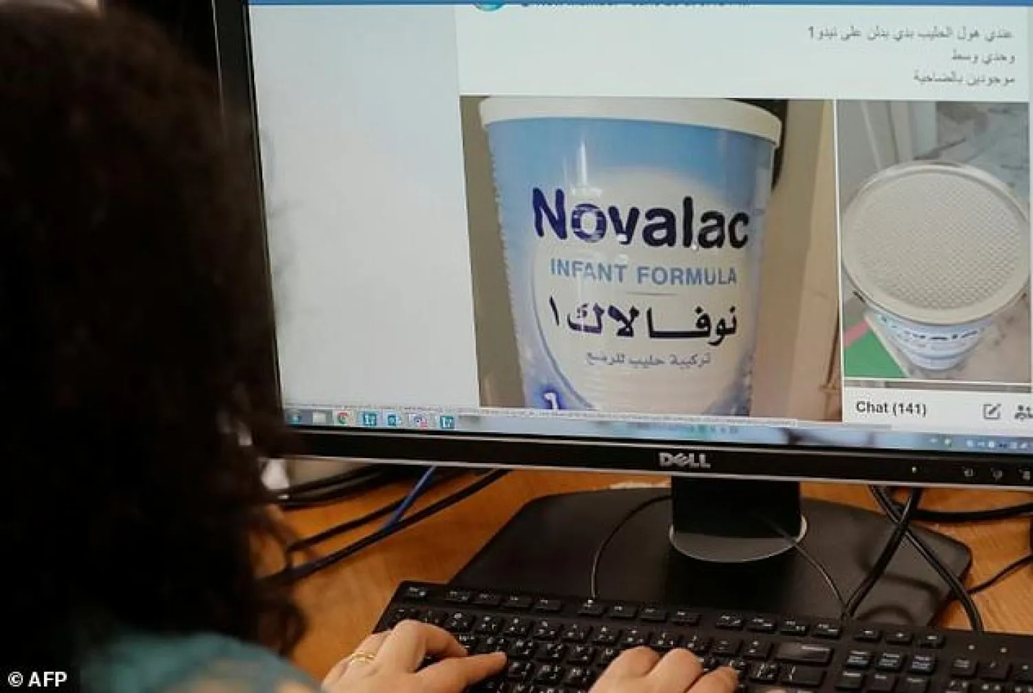 A Lebanese woman checks a Facebook page where people exchange their goods with food, baby clothes and diapers. AFP