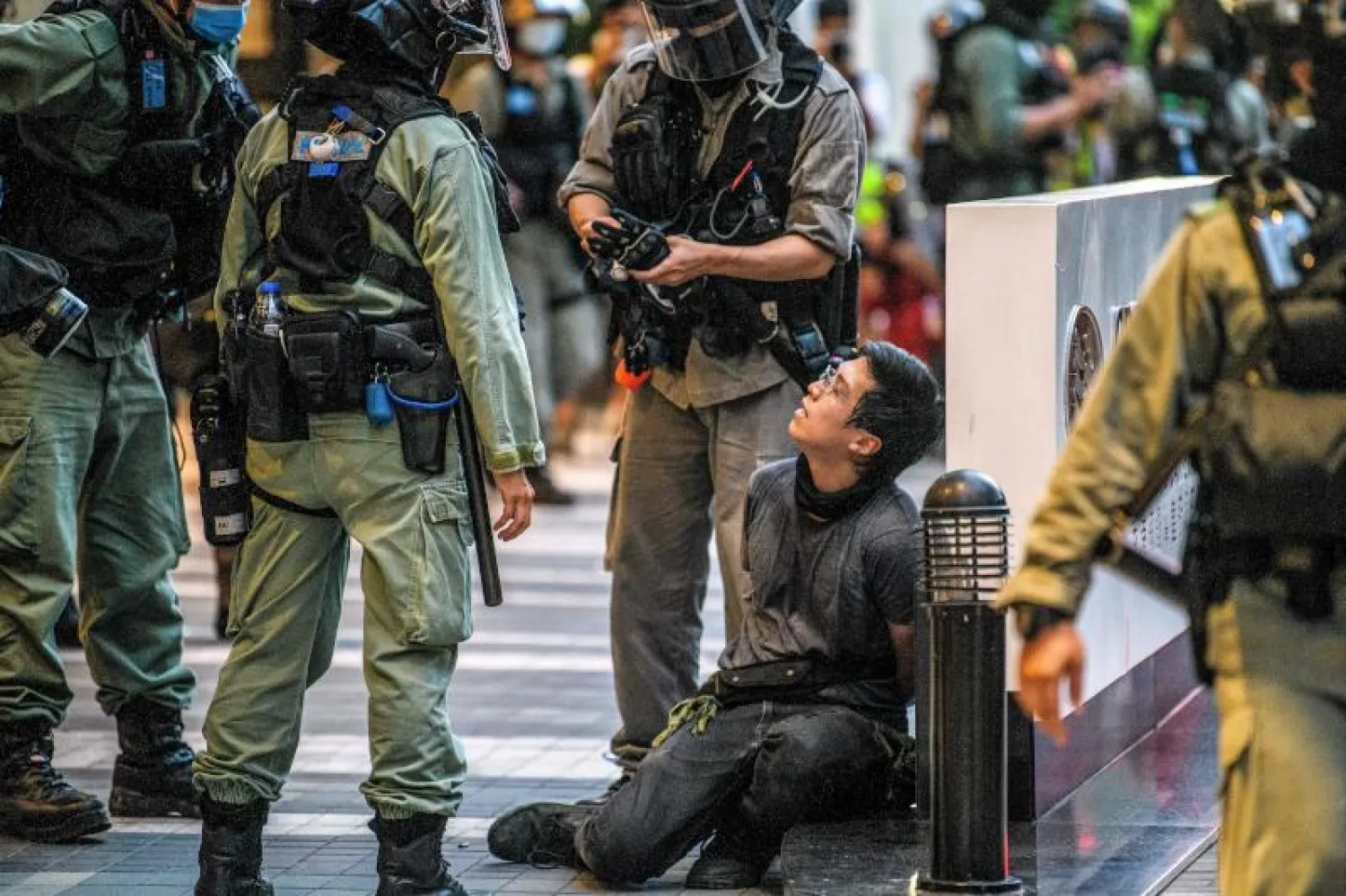 محتج أوقفته الشرطة في هونغ كونغ خلال مسيرة مناهضة لقانون الأمن القومي (أ.ف.ب)
