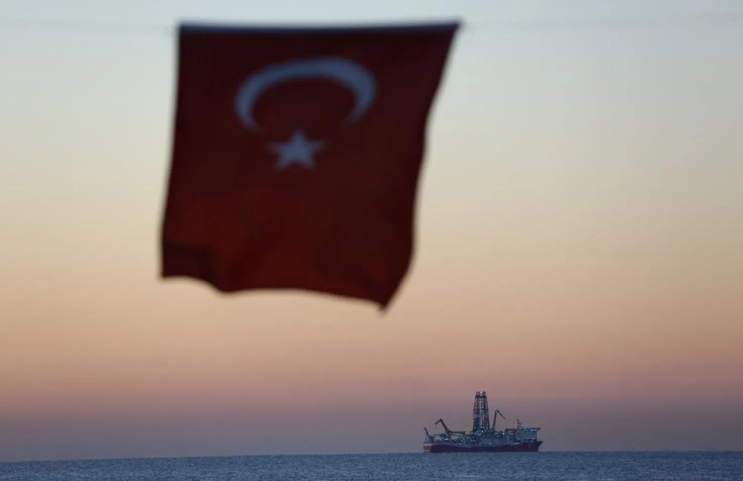 The Turkish national flag hangs in the foreground as drilling vessel Fatih is seen off the Mediterranean resort city of Antalya, Turkey October 30, 2018. REUTERS/Kaan Soyturk