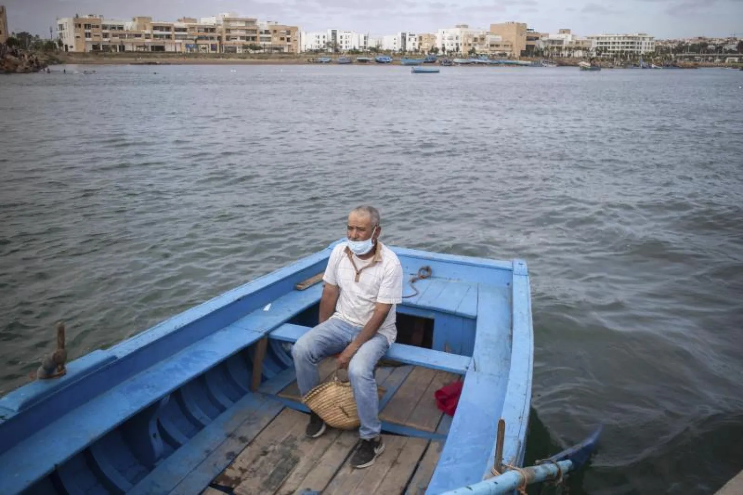 مغربي يرتدي كمامة رغم رفع إغلاق كورونا (أ.ب)