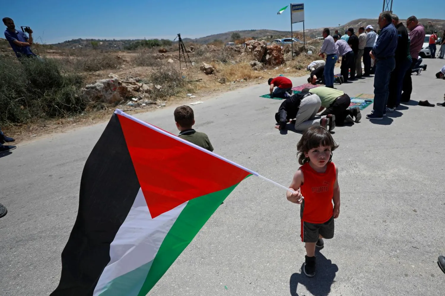 FILE PHOTO: A boy holds a Palestinian flag during a protest against Israel's plan to annex parts of the occupied West Bank, in Beta village near Nablus June 12, 2020. REUTERS/Mohamad Torokman