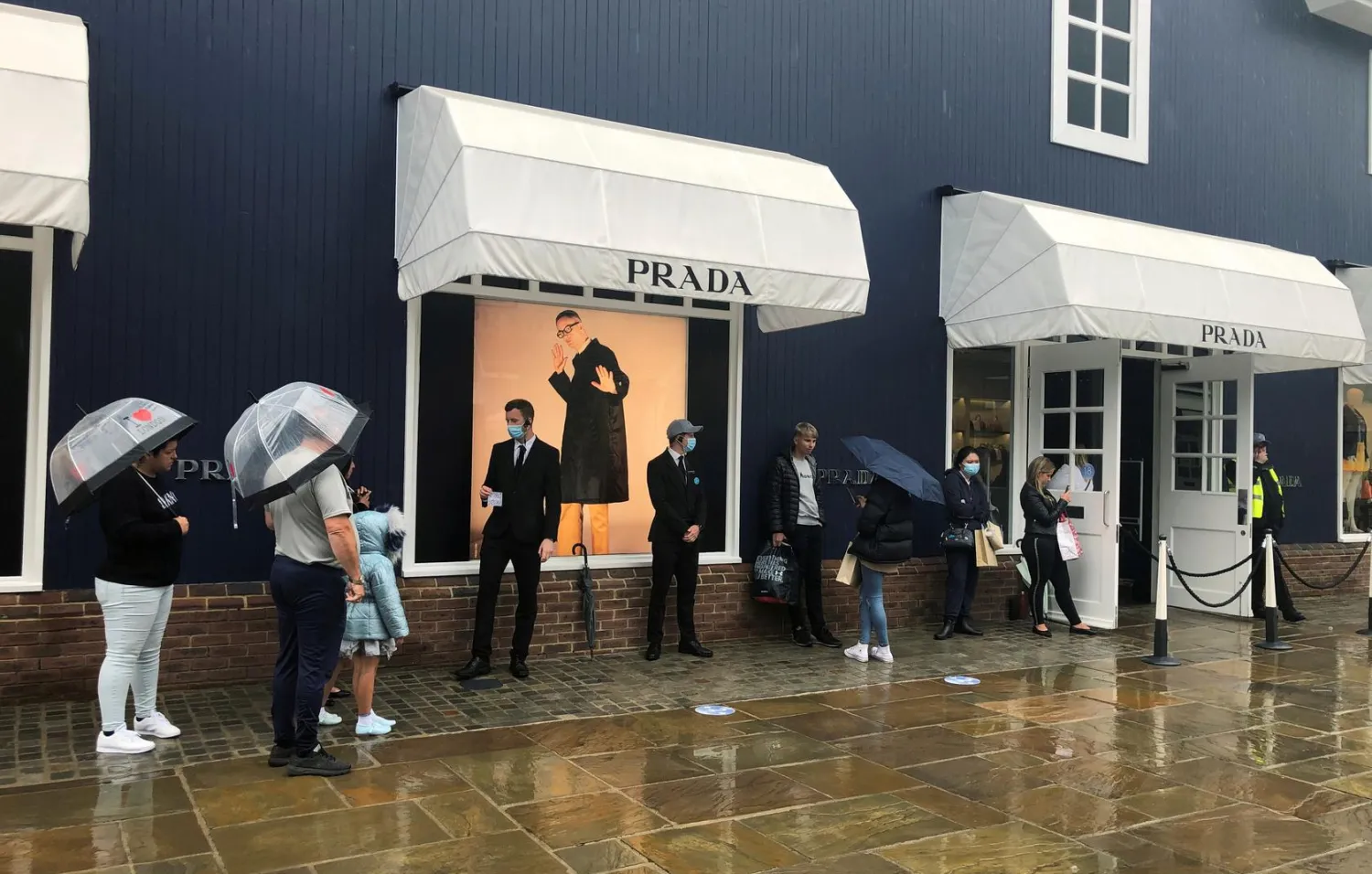 FILE PHOTO: Shoppers are seen queuing outside the Prada shop at Bicester Village, amid the spread of the coronavirus disease (COVID-19), in Bicester, Britain, June 18, 2020. REUTERS/Eddie Keogh/File Photo

