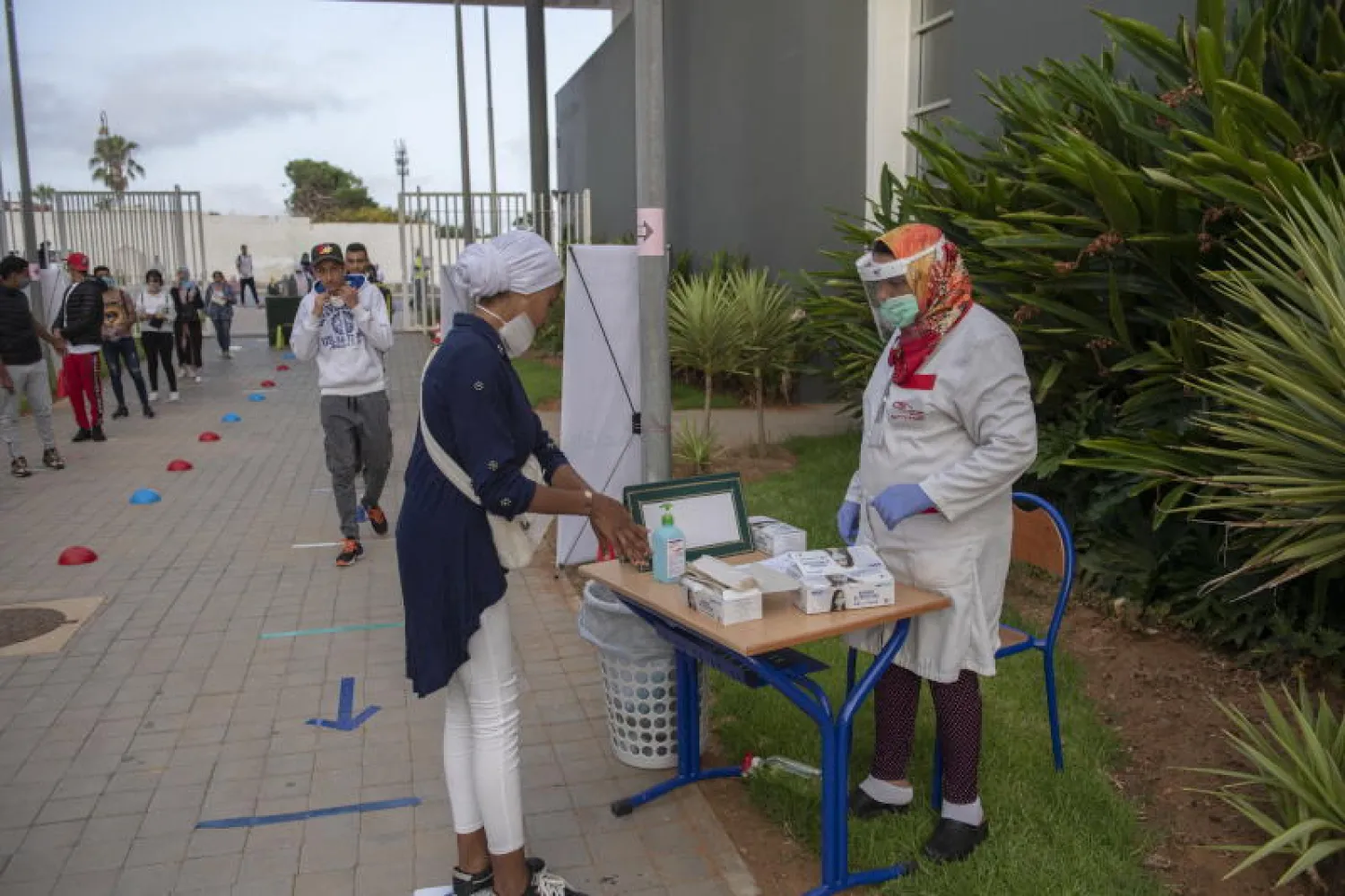 طلاب ينتظرون دورهم في التعقيم قبل دخول الاختبارات في الرباط (إ.ب.أ)