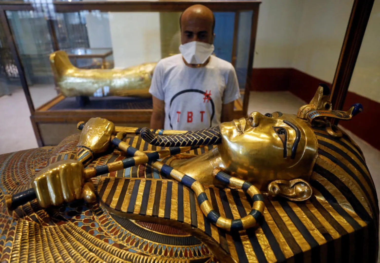 سائح ينظر إلى تمثال الملك توت عنخ آمون أثناء زيارته للمتحف المصري (رويترز)