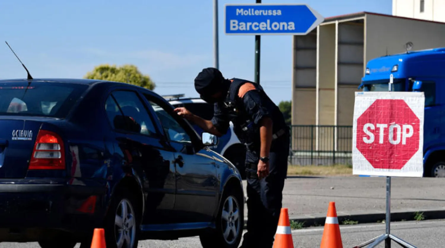 شرطي كاتالوني يراقب مدخل مدينة ليريدا التي أعيد فرض الحجر عليها أمس (أ.ف.ب)