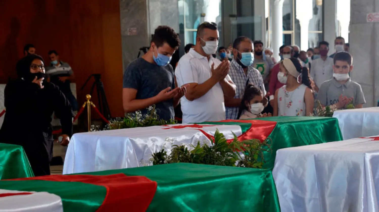 جزائريون يترحمون على رفات 24 من كبار قادة المقاومة الشعبية في قصر الثقافة بالعاصمة الجزائرية أمس (أ.ف.ب)