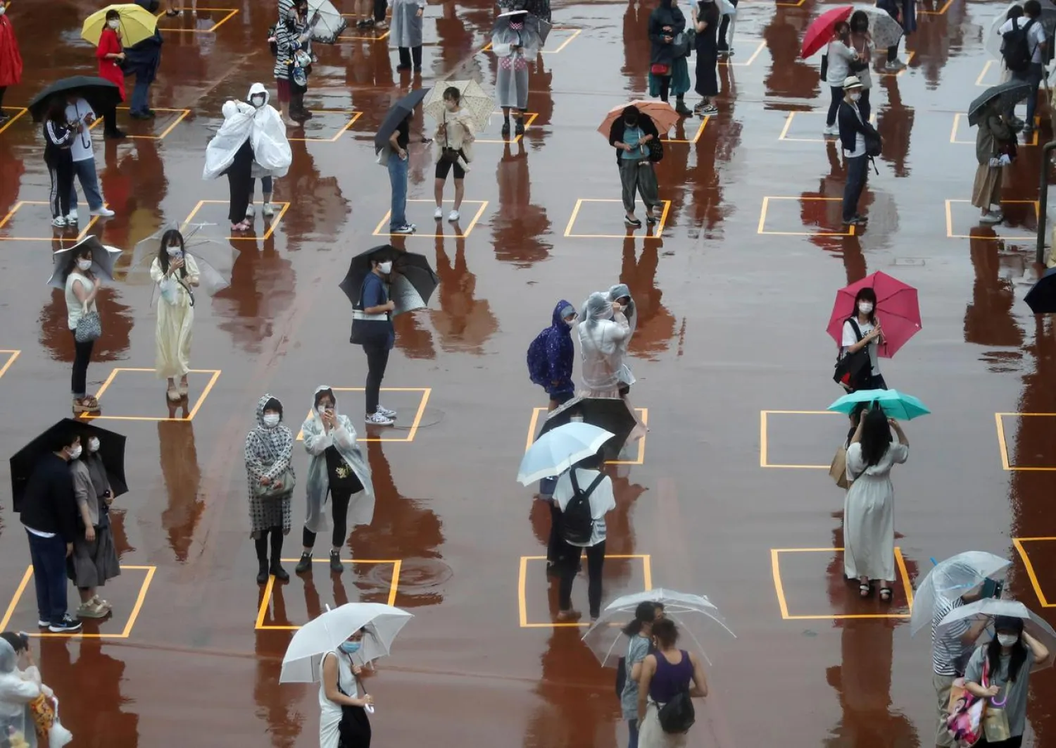 Visitors practice social distancing while waiting to enter Tokyo DisneySea, which closed for months due to the coronavirus, in Urayasu, east of Tokyo, Japan July 1, 2020. (Reuters)