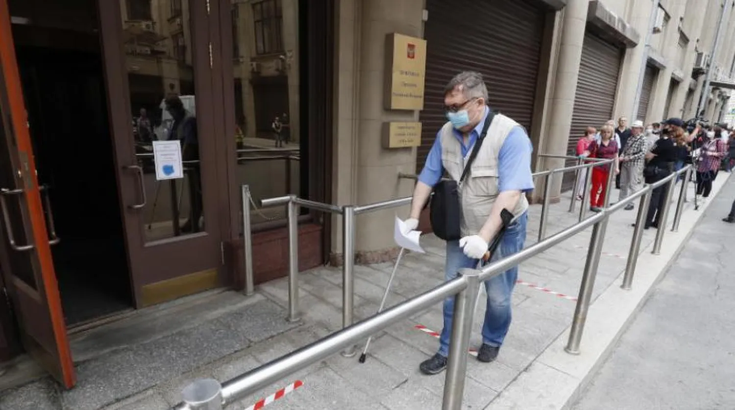 Moskova'da anayasal değişikliklerle ilgili referandumda oy kullanmak üzere maske ile sandık başına giden bir vatandaş (EPA))