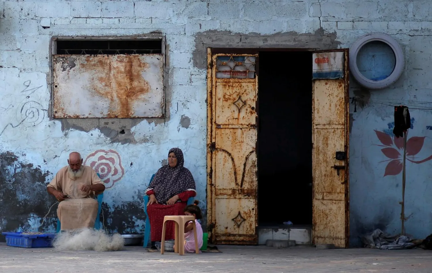 A Palestinian man repairs a fishing net outside his house at Al-Shati refugee camp, in Gaza City on September 1, 2018. REUTERS/Mohammed Salem