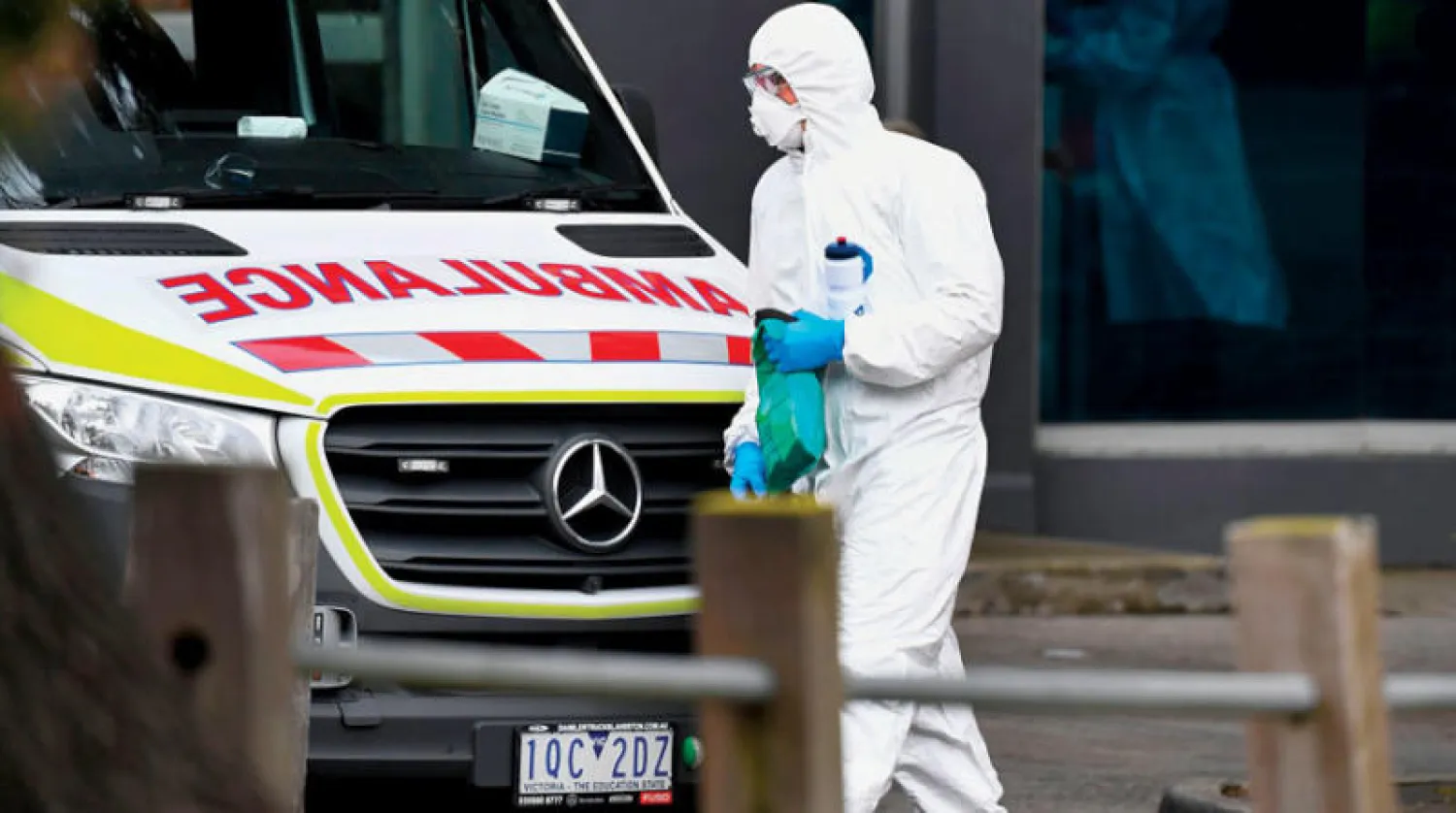 مسعف في أحد شوارع ملبورن التي تفشى فيها «كورونا» (أ.ف.ب)