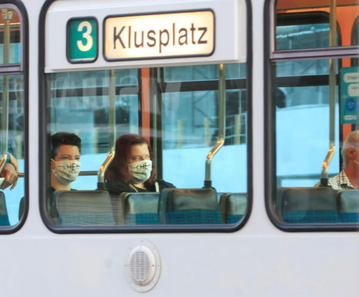 ركاب يرتدون أقنعة واقية أثناء جلوسهم في ترام للنقل العام في زيوريخ (رويترز)