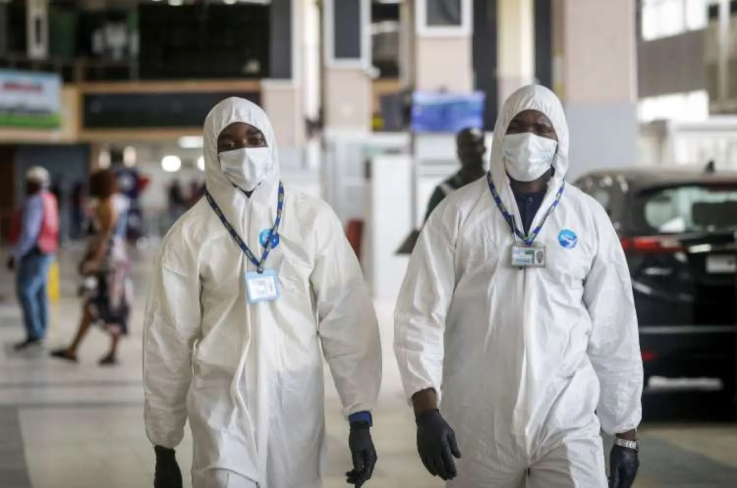 In this Tuesday, April 7, 2020 file photo, Nigerian aviation workers wear protective clothing as US citizens queue to check in and be repatriated aboard an evacuation flight arranged by the US embassy and chartered with Delta Air Lines, at the Murtala Mohammed International Airport in Lagos, Nigeria. (AP Photo/Sunday Alamba, File)