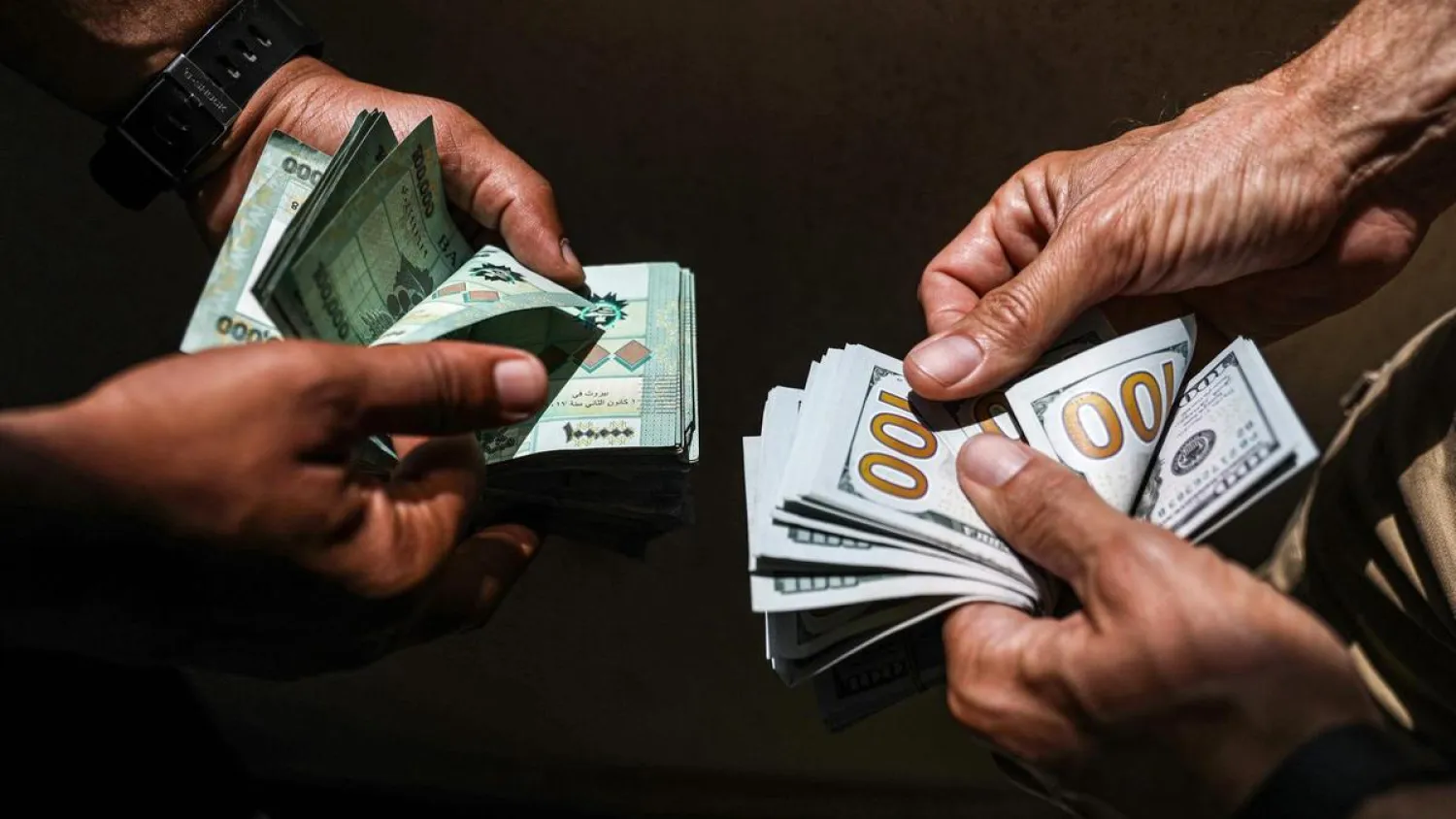 People exchange Lebanese pound and US dollar notes on the black market in Lebanon's capital Beirut. (AFP)