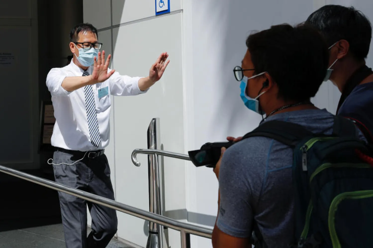 قوات أمن تواجه صحافياً لدى اقترابه من فندق في هونغ كونغ يُعتقد أنه يستخدم مقراً مؤقتاً لوكالة الأمن القومي (رويترز)