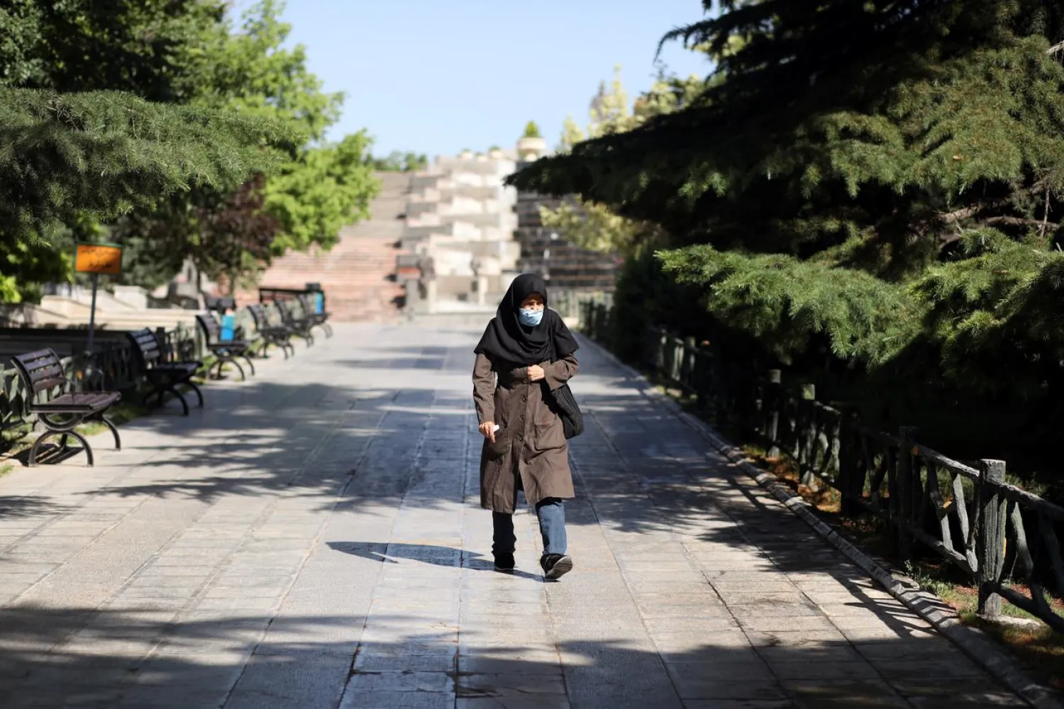 An Iranian woman wearing a protective face mask walks in a park, following the outbreak of the coronavirus, in Tehran, Iran June 12, 2020. (Reuters)