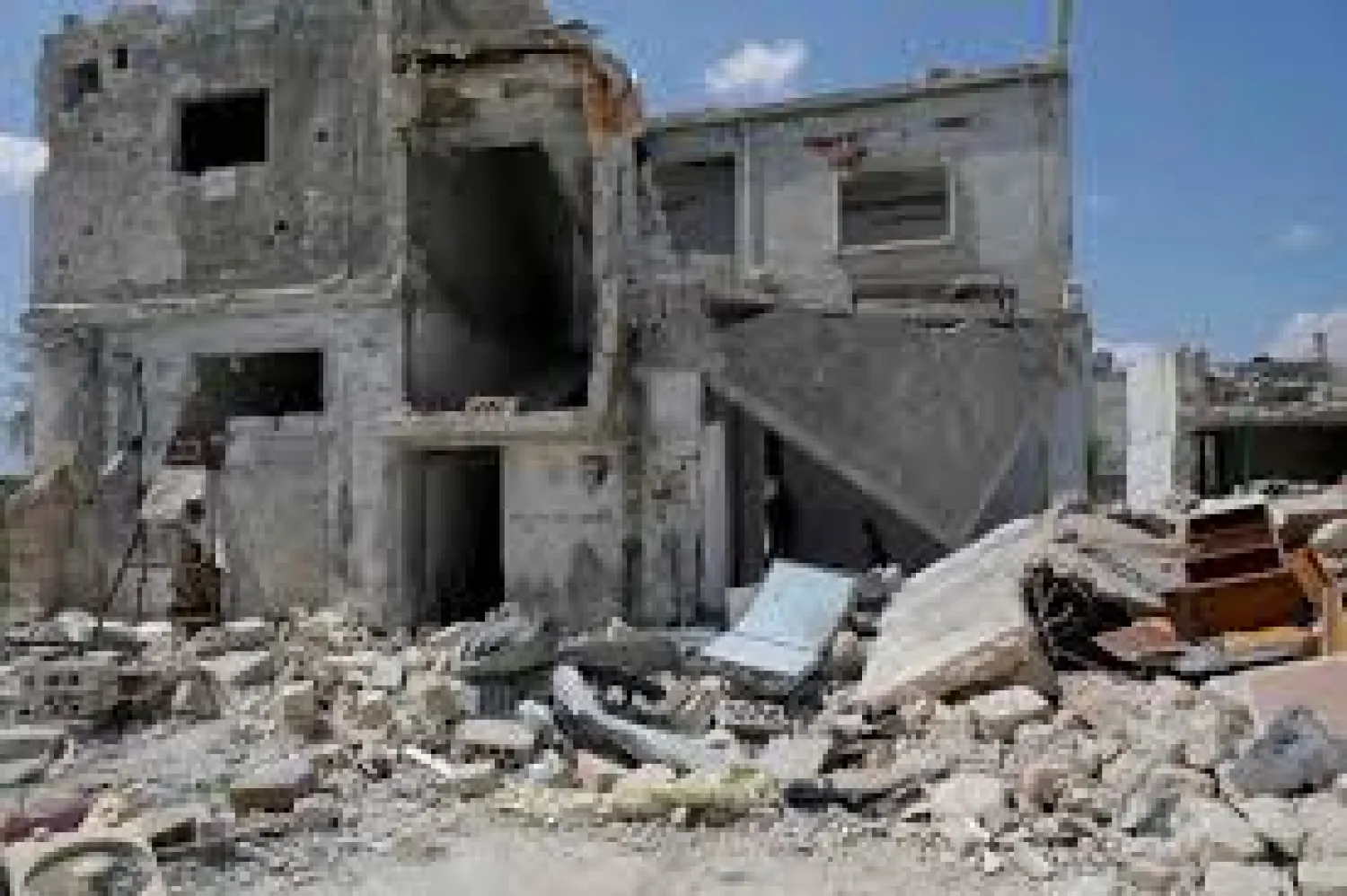 Saher al-Ali's family members stand inside their damaged house in the rebel-held town of Nairab, Idlib region, Syria April 17, 2020. Picture taken April 17, 2020. REUTERS/Khalil Ashawi/File Photo