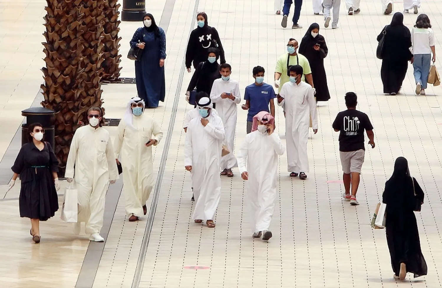 Kuwaitis wearing face masks walk inside the reopened Avenues Mall, the country's largest shopping center on June 30, 2020 in Kuwait City. (AFP)