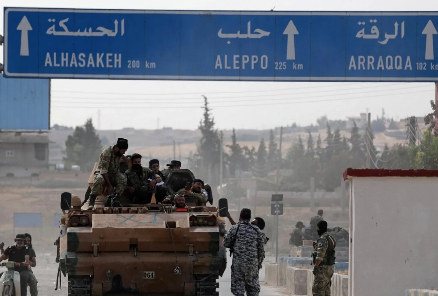 Turkey-backed Syrian fighters sit on a military truck at the border town of Tal Abyad, Syria. (Reuters)