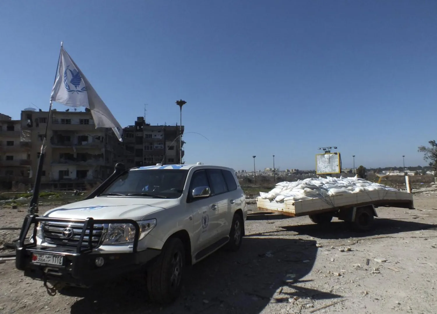 A United Nations vehicle towing a trailer with humanitarian aid arrives at a besieged area of Homs February 12, 2014. REUTERS/Yazan Homsy