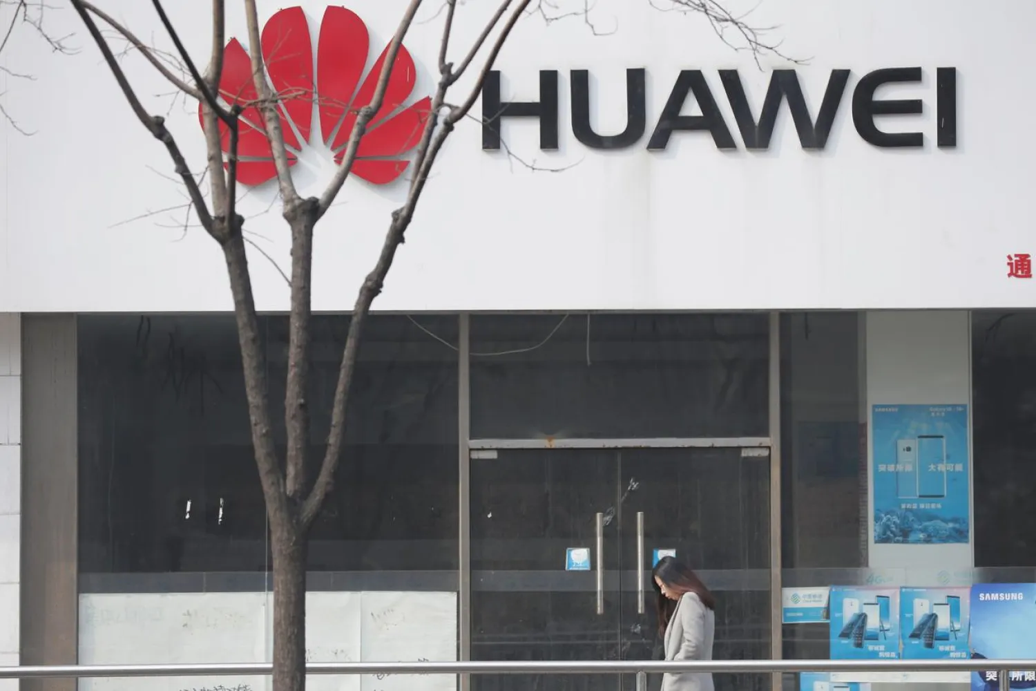 A woman walks past a Huawei store in Beijing, China March 2, 2019. REUTERS/Jason Lee