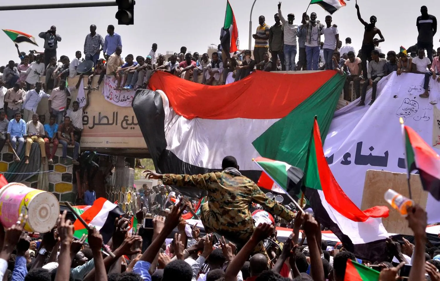 A military officer is carried by the crowd as demonstrators chant slogans and carry their national flags outside Defense Ministry in Khartoum, Sudan April 11, 2019. REUTERS/Stringer