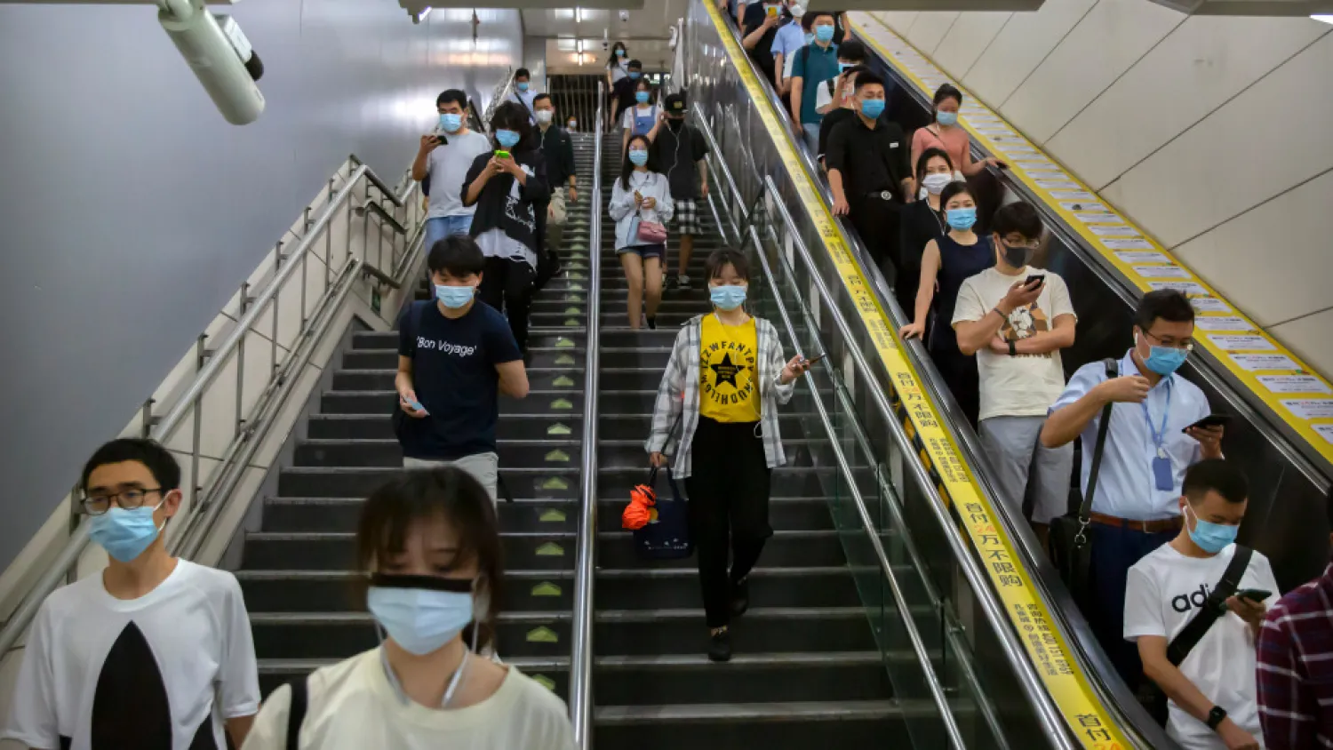 Commuters wearing face masks to protect against the spread of the new coronavirus walk through a subway station in Beijing, Thursday, July 9, 2020. (AP Photo/Mark Schiefelbein)

