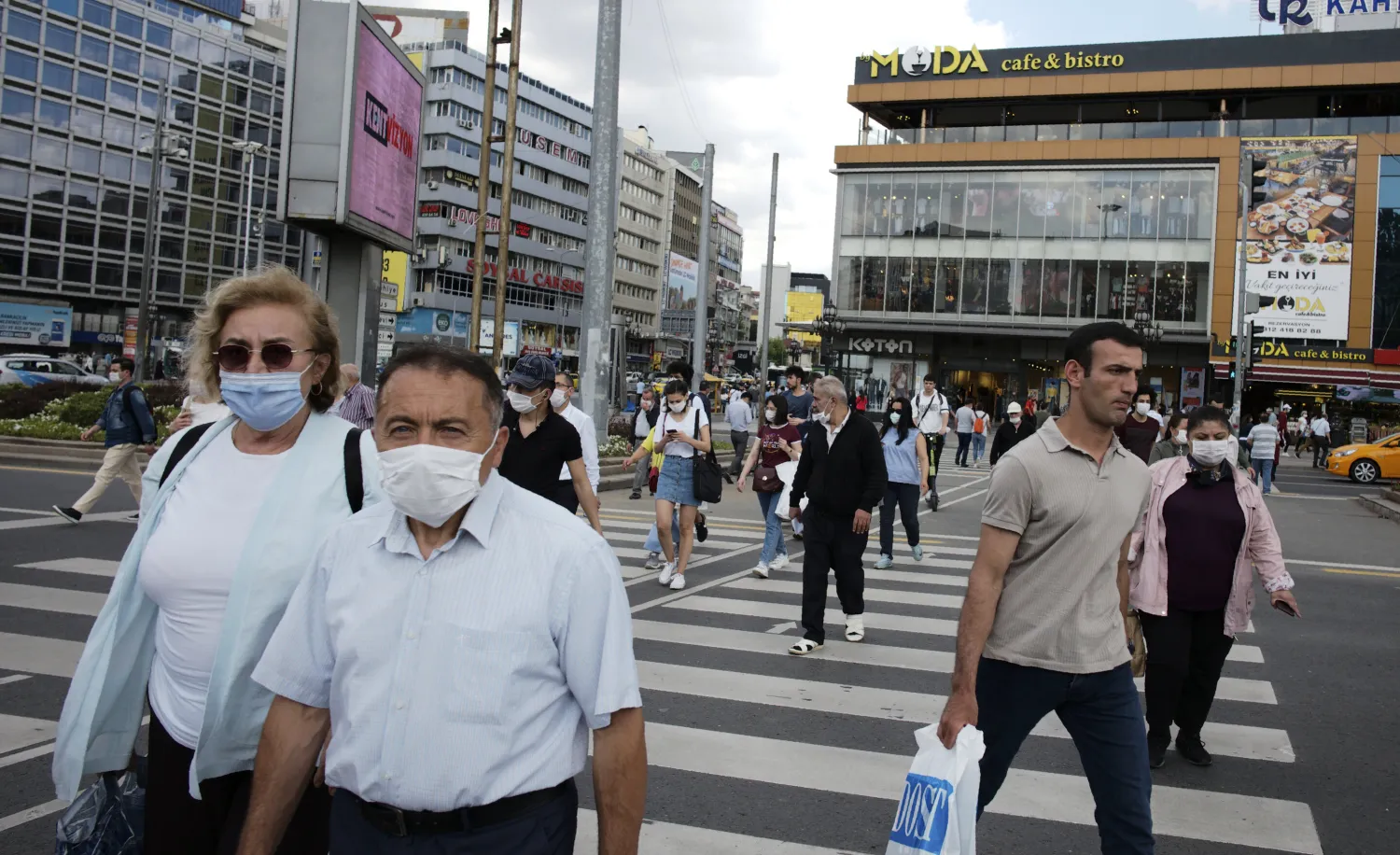 People wearing face masks to protect against the spread of coronavirus, walk in the main Kizilay Square, in Ankara, Turkey, Tuesday, June 16, 2020. AP Photo/Burhan Ozbilici)