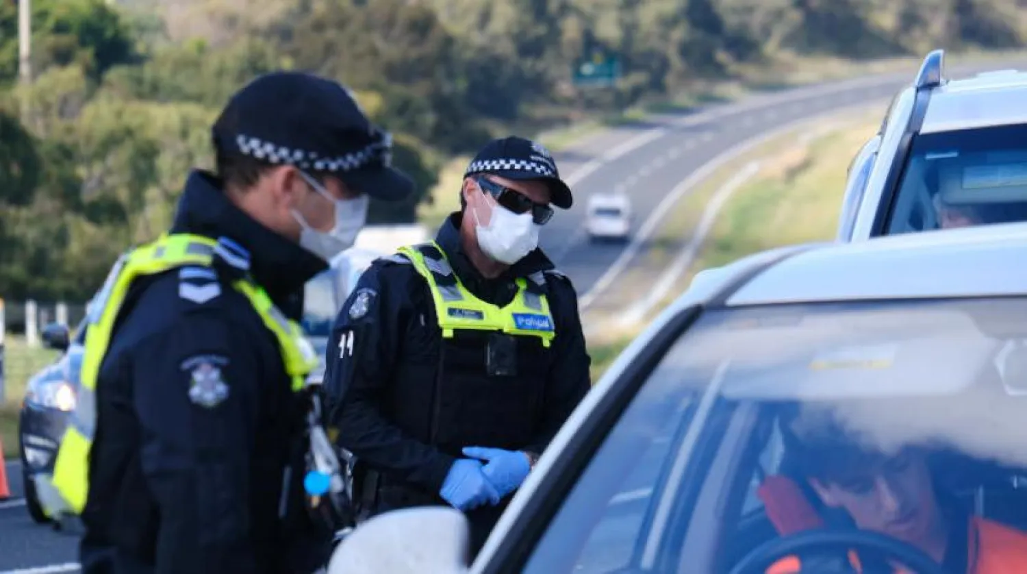 Yeni bir koronavirüs (Kovid-19) dalgasını önlemek için tecrit uygulamalarının bir parçası olarak Victoria eyaletinde kurulan bir kontrol noktasında görev yapan Avustralya polisi (Reuters)