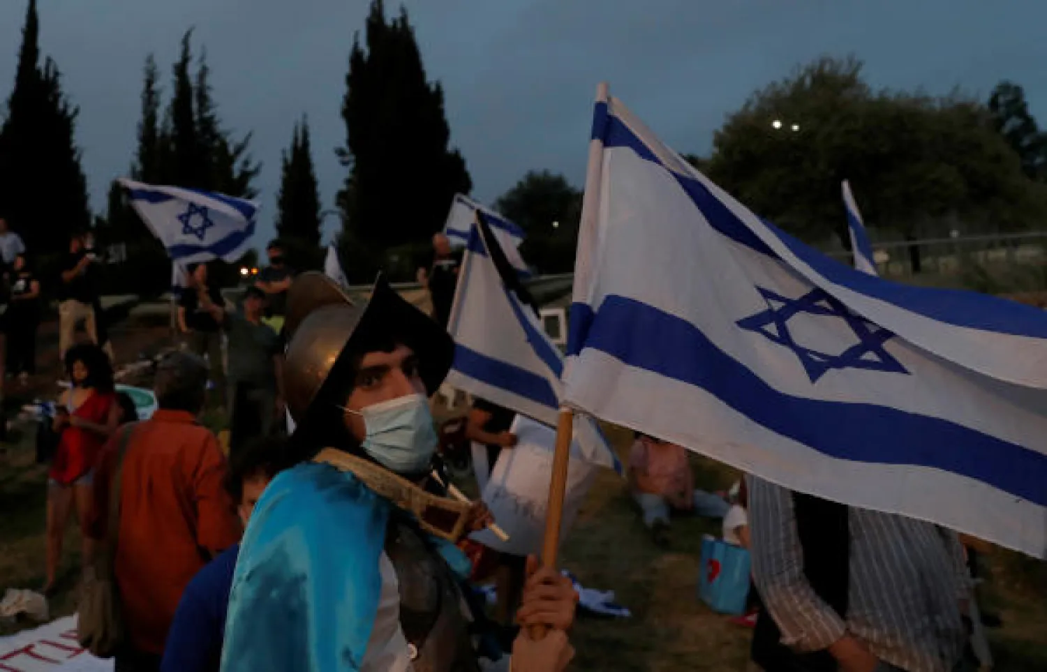 A protester waves a flag during a demonstration against Israeli Prime Minister Benjamin Netanyahu's new unity government with rival Benny Gantz, outside the Knesset, Israel's parliament, in Jerusalem May 14, 2020. REUTERS/Ronen Zvulun
